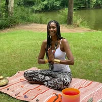 Vanessa 'Willow' Johnson, The Willow Tree Lady, seated in meditation beside the water